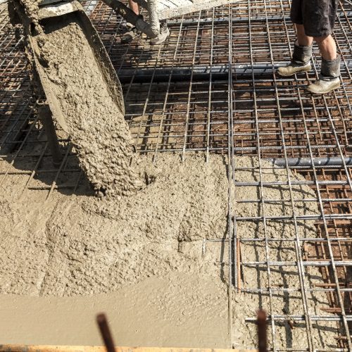 Pouring concrete into the construction of the house. Builders are pouring ready-mixed concrete